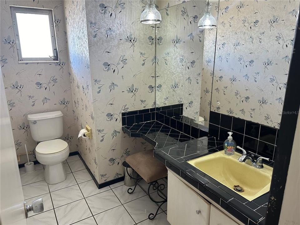1/2 bath located off the primary bedroom - area to add shower by converting front entry closet.