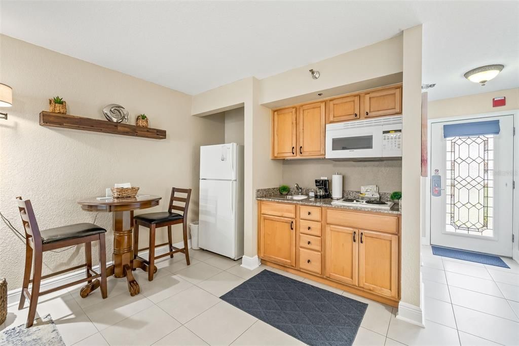Kitchenette with coffee maker, cooktop, microwave and eat-in kitchen.
