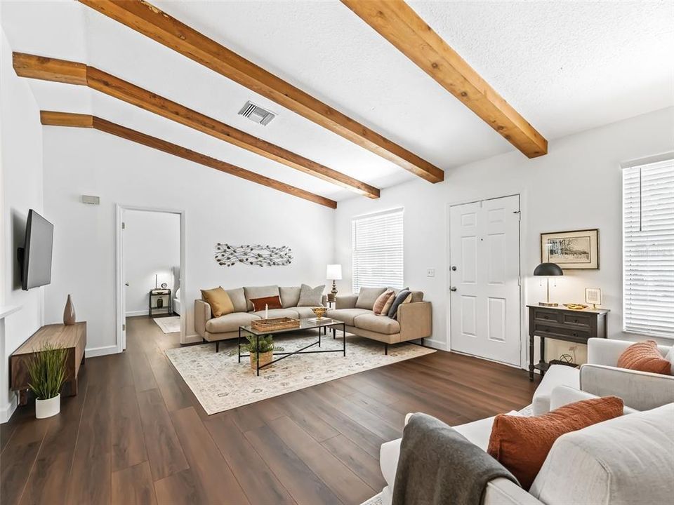 Living Room featuring new Luxury Plank Vinyl Flooring, Vaulted Ceilings with Cedar Beams and Floor to Ceiling, Brick Wood Burning Fireplace