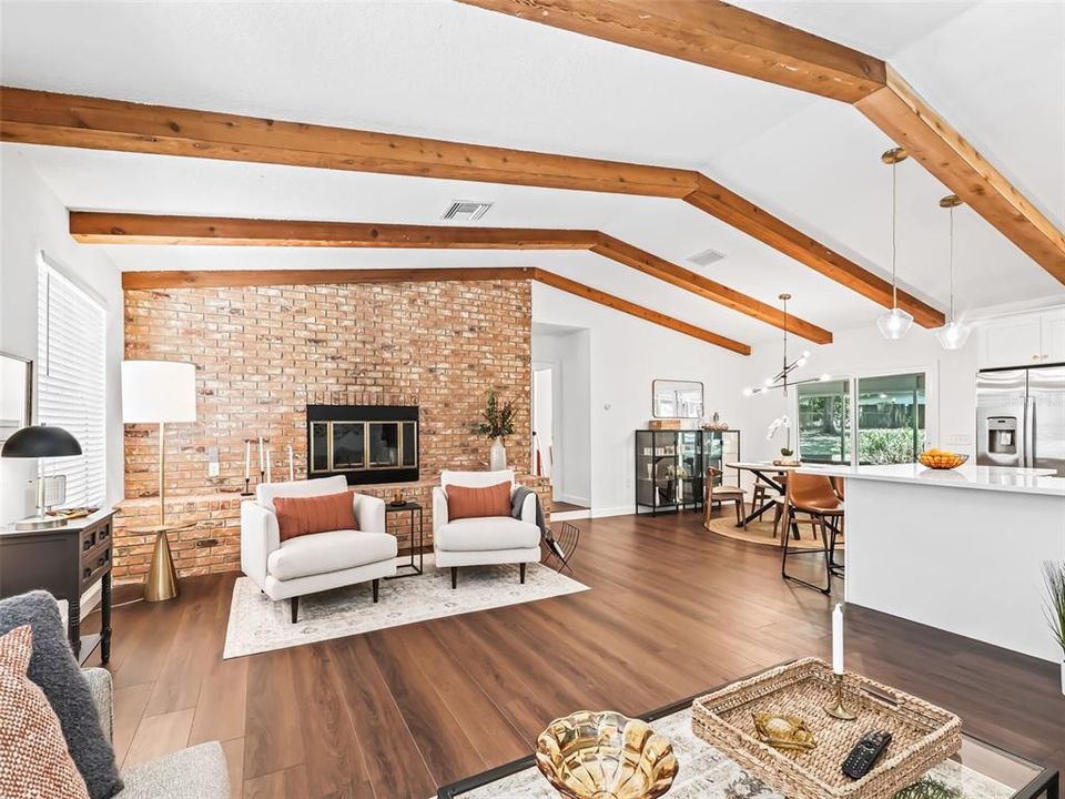 Living Room featuring new Luxury Plank Vinyl Flooring, Vaulted Ceilings with Cedar Beams and Floor to Ceiling, Brick Wood Burning Fireplace