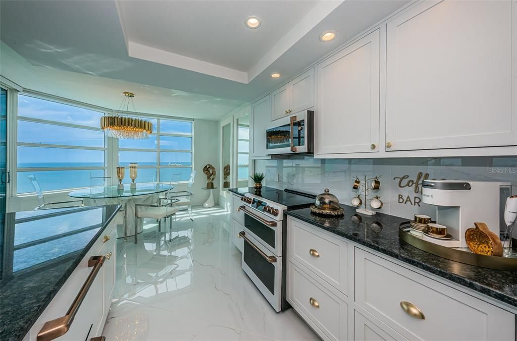 Contemporary Cucina Features the GE Cafe Collection White Rose with Gold Accents, Double Convention Oven, Double Compartment Dish Washer, Granite Surfaces, Soft Close Custom Cabinentry & More!