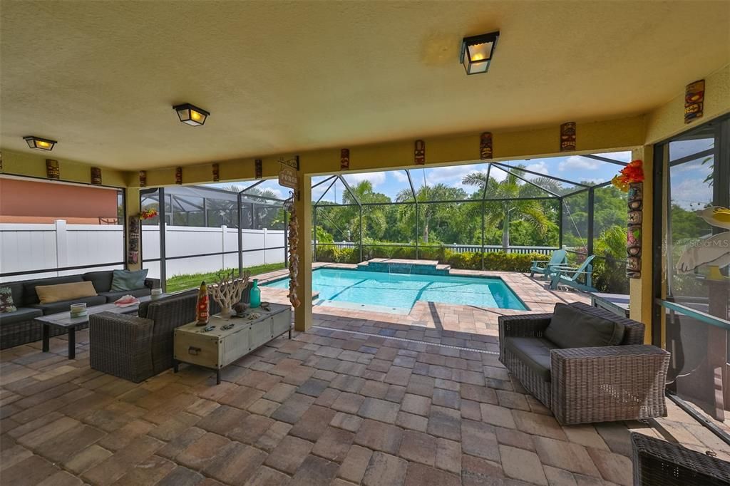 Extended covered patio & view of the pool and conservation area