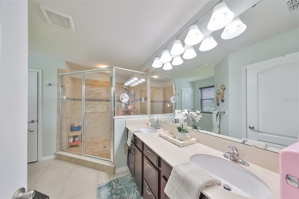 Spacious primary bathroom with double sink and large walk-in shower