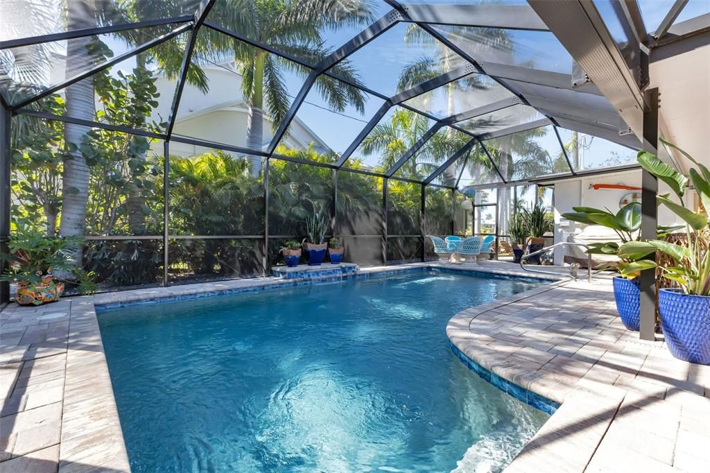 and THERE IS A WONDERUL HEATED SALTWATER POOL WITH COBALTO ACCENT TILE, AQUA BLUE WATER, A MURMURING FOUNTAIN, SWAYING PALMS, AND  AN EXPANSIVE PAVER DECK TO ENJOY