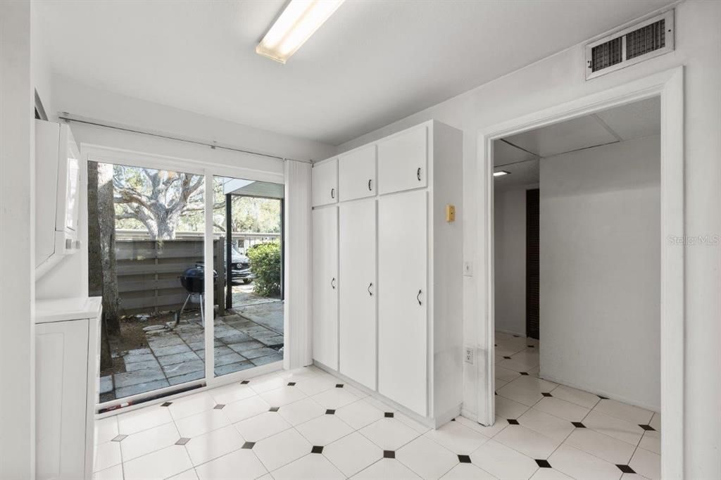 Spacious kitchen featuring ample cabinetry, laundry, a dinette, and direct access to the front courtyard.