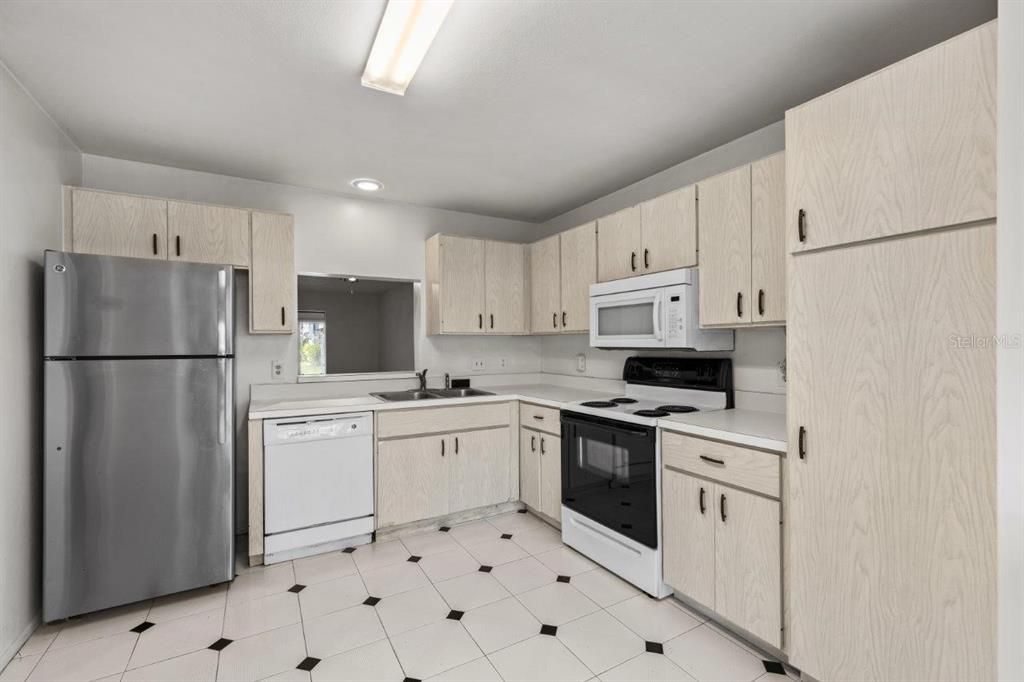 Spacious kitchen featuring ample cabinetry, laundry, a dinette, and direct access to the front courtyard.