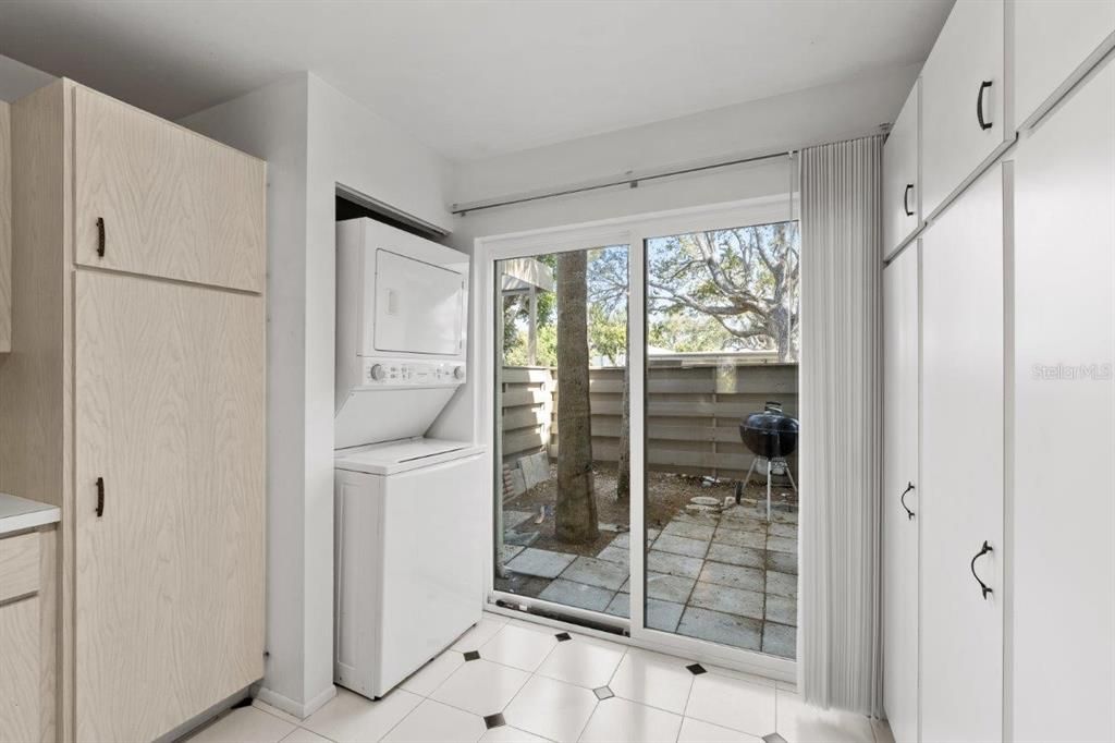 Spacious kitchen featuring ample cabinetry, laundry, a dinette, and direct access to the front courtyard.