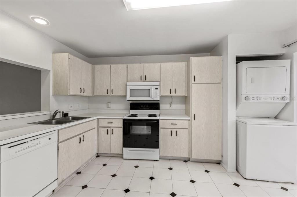 Spacious kitchen featuring ample cabinetry, laundry, a dinette, and direct access to the front courtyard.