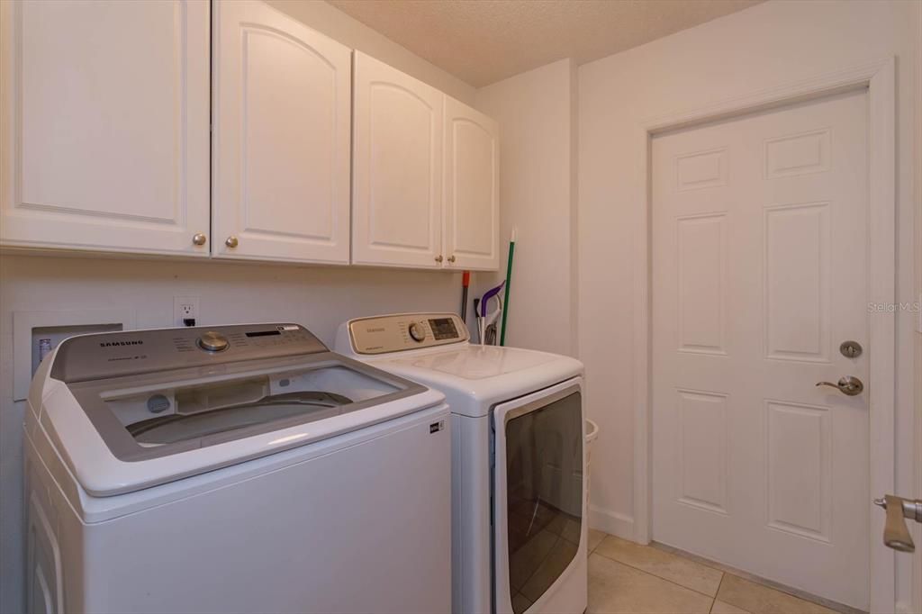 Laundry room that can fit full size washer and dryer and has additional storage space.