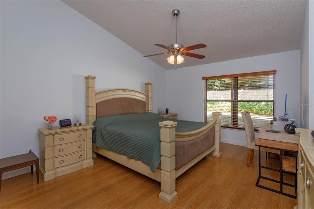 Master bedroom that has expansive ceilings, a walk in closet and overlooks the covered patio and backyard.