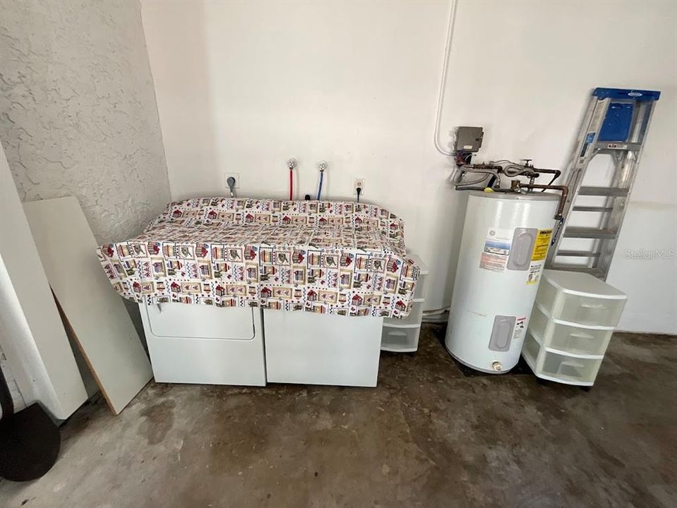 Laundry area in garage and comes with a washer and dryer.
