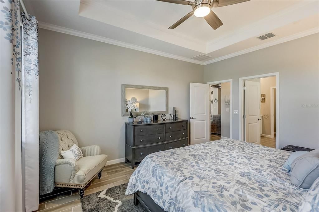 Spacious primary bedroom with trey ceiling & crown molding