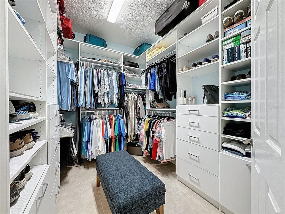 Primary closet features a custom designed built-in organizer with shelves