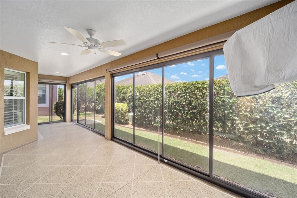 The painted flooring adds a touch of class to the glass enclosed lanai.  The privacy hedge is an added bonus.