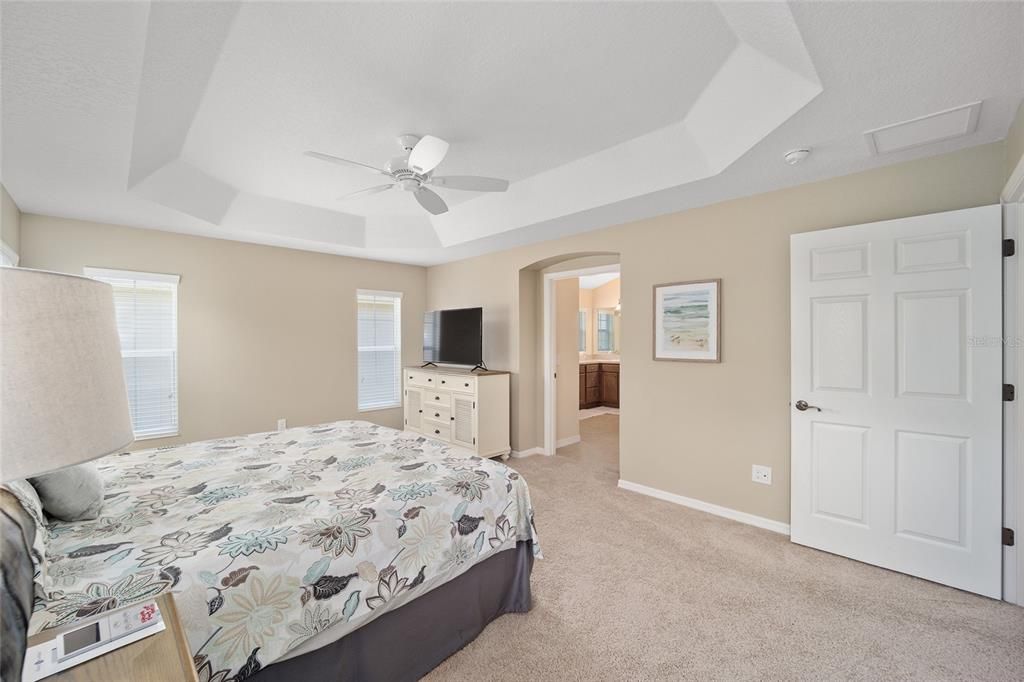 The primary suit with a trey ceiling looking toward the bathroom. The open door in the right leads to the livingroom.