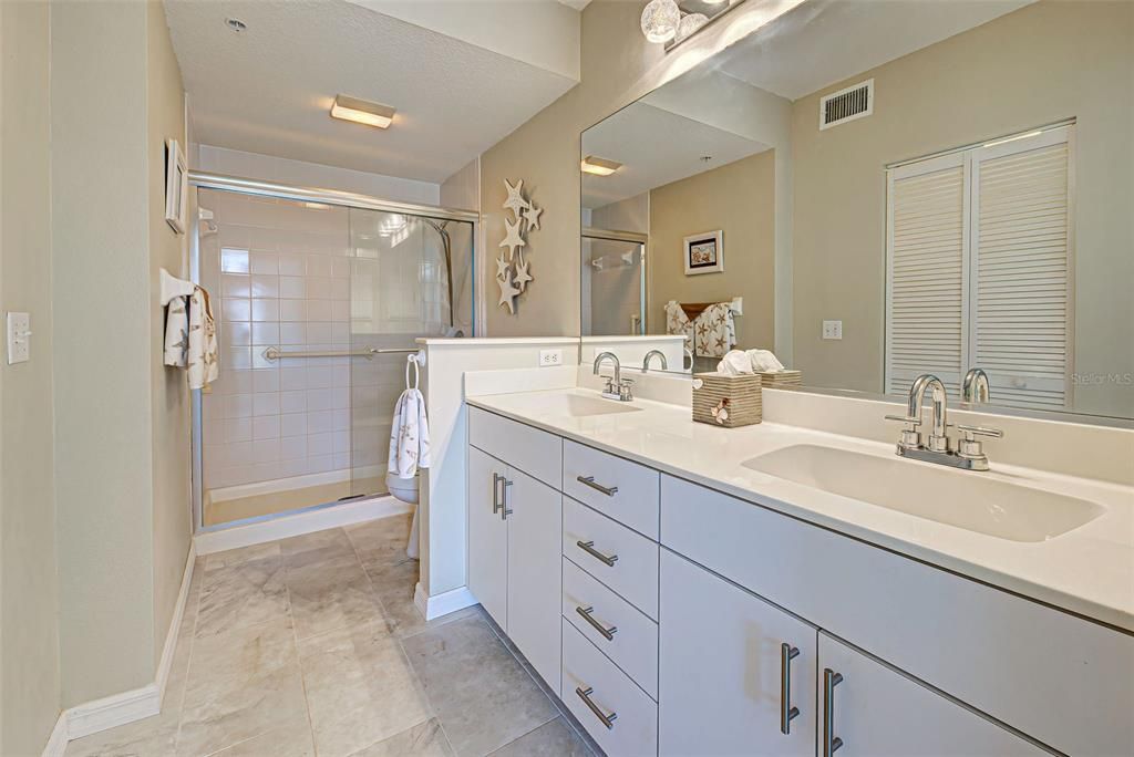 Spacious ensuite bathroom features dual sinks, porcelain tiles and plenty of storage.