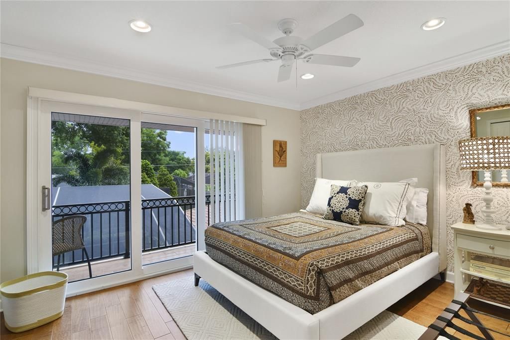 The second-floor guest bedroom has a slider leading to an outdoor balcony.