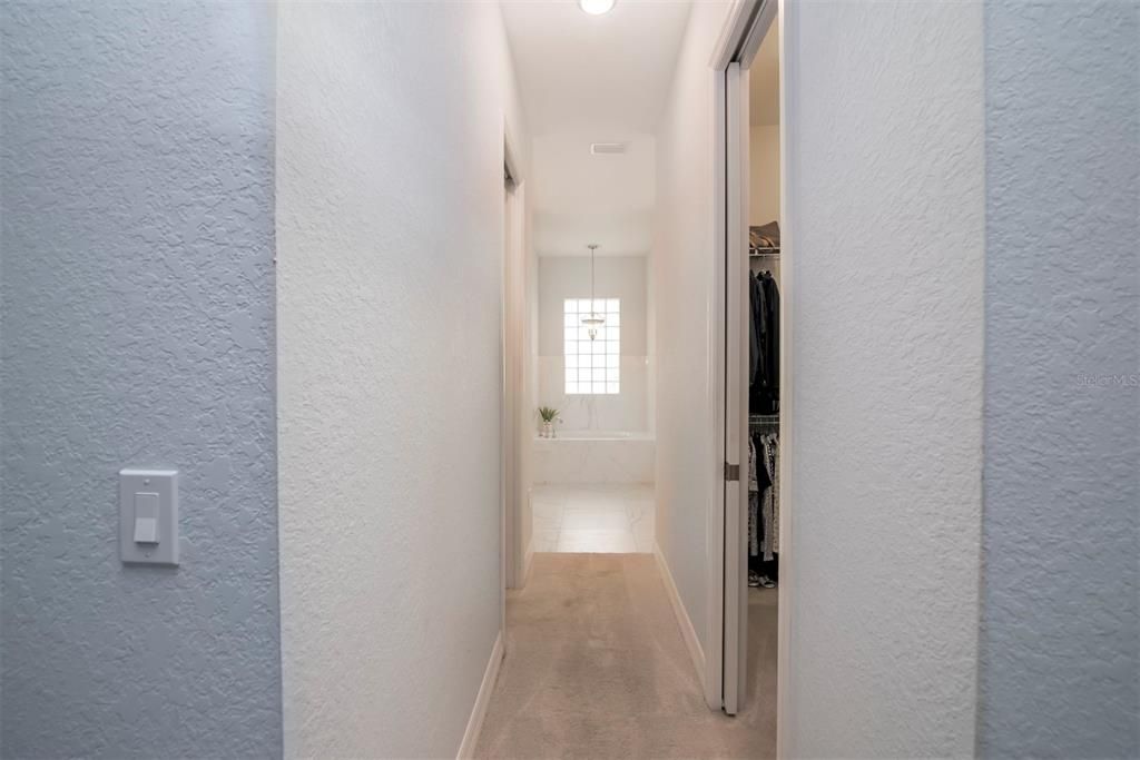 The hallway that connects the master bedroom to the master bath holds the 2 large walk-in closets. Each closet has dual height shelving and pocket doors.