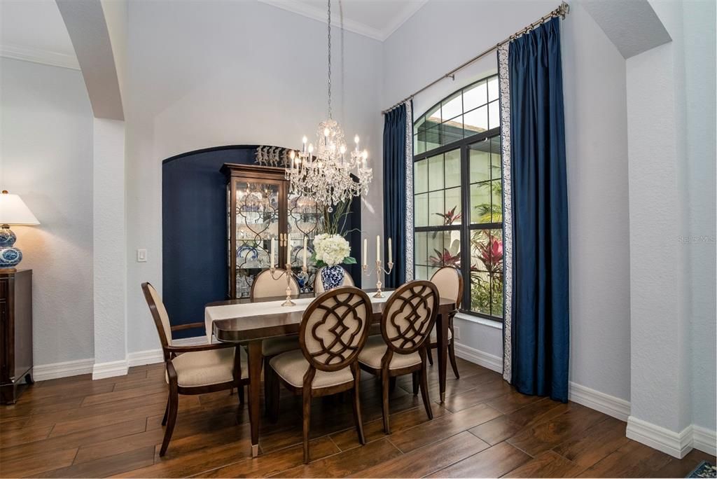 The dining area is defined by graceful arches and pillars. The high ceiling adds to the feeling of spaciousness.