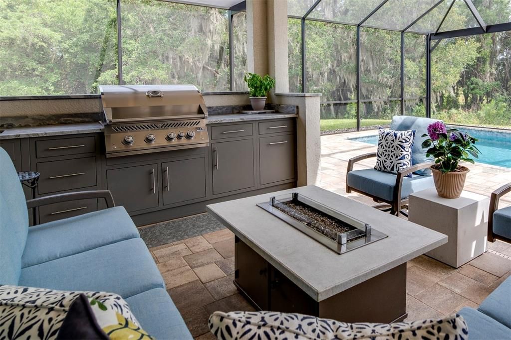 The summer kitchen has custom cabinets, sink, and a built-in Napoleon grill.