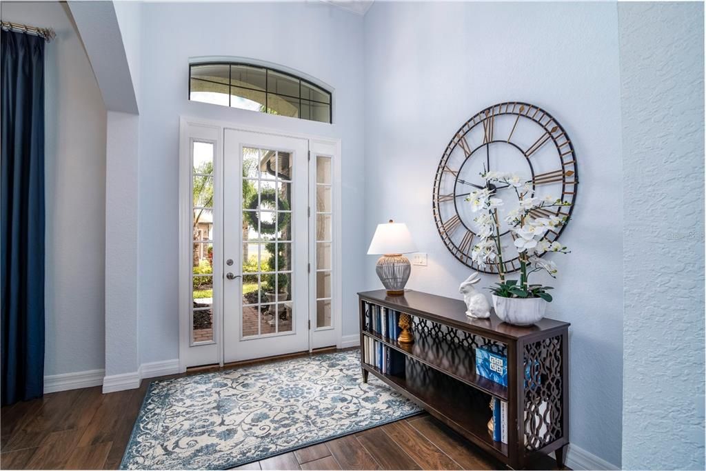 The welcoming foyer gets great natural light from the paned glass front door, sidelights, and the over the transom window.