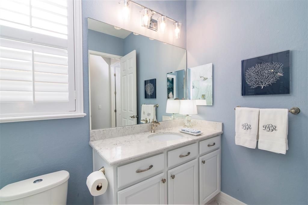 The elevated vanity has upgraded lighting and plumbing fixtures. The dual flush elongated toilet saves water.