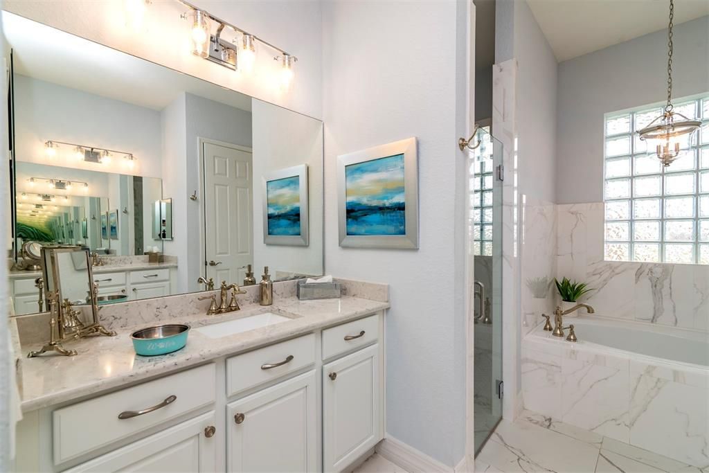 The master bath has dual elevated vanities with quartz counters, upgraded lighting and plumbing fixtures.
