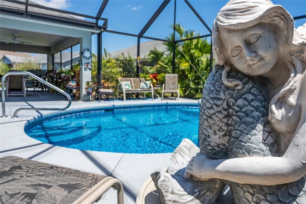 The poolside MERMAID STATUE seems to listen to the mesmerizing sounds of the cascading waterfall feature.