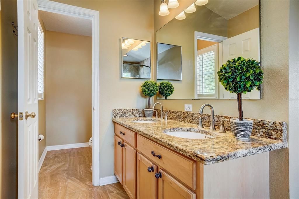 Lovely primary bath with granite counters, dual vanity & water closet
