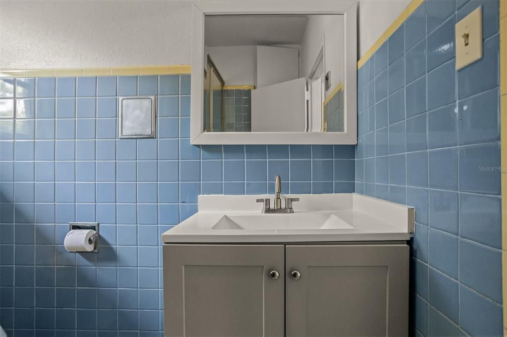 Charming baby blue kennedy bathroom with tub and shower, new toilet and vanity.