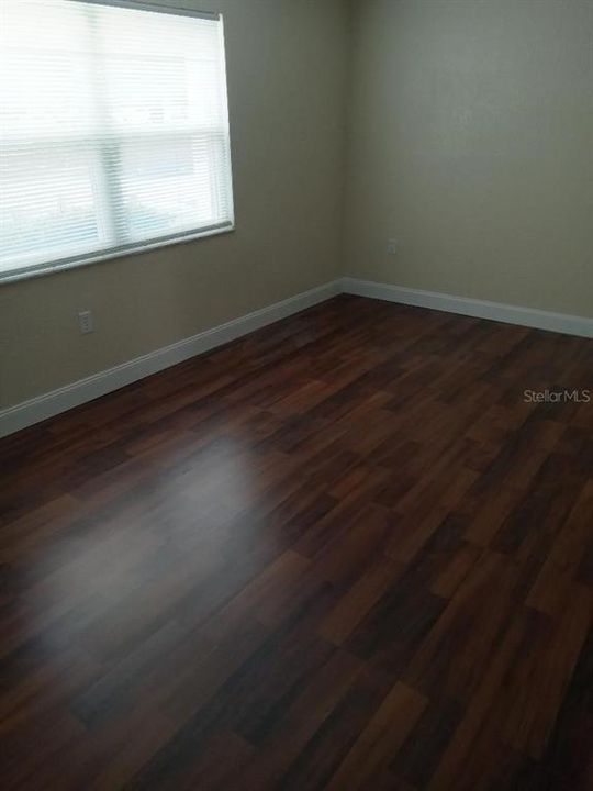 Bedroom with new flooring and baseboards