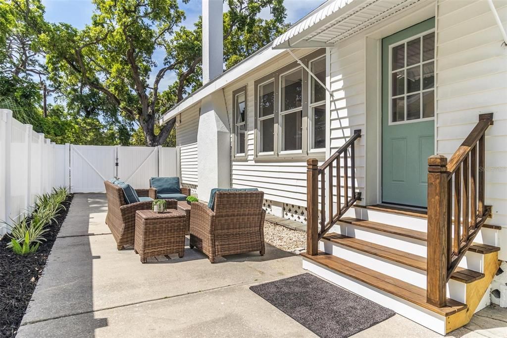 This doorway to the right is off the kitchen and leads to this multi-purpose area which can be used as a driveway or a sitting area, as pictured here.  the sturdy, attractive stairway is brand new.  There is a double gate from the front, leading to this area.