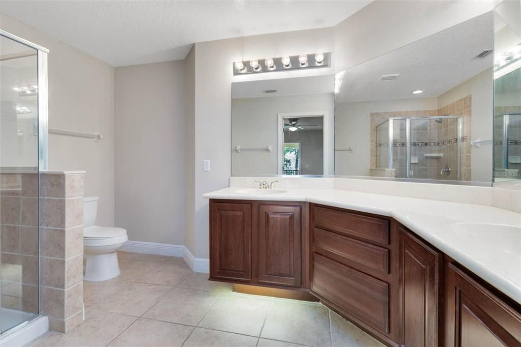 Your primary ensuite bath features dual sinks, ample cabinet space, modern under-cabinet lighting, and a shower.