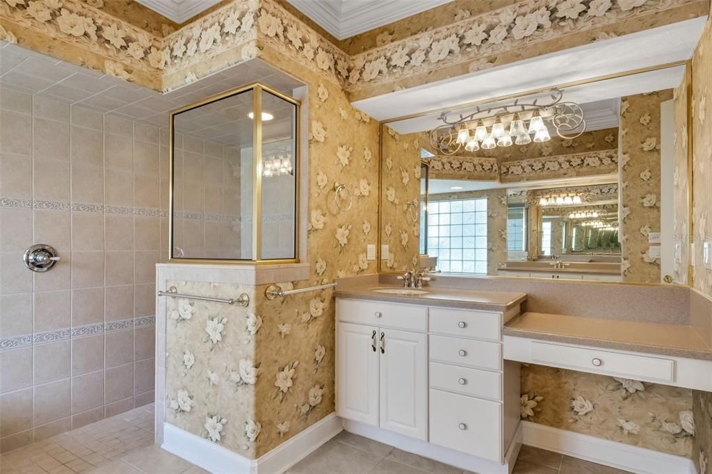 Her vanity side of the primary bathroom , features a make-up space and plenty of storage. The walk in shower is large as well.