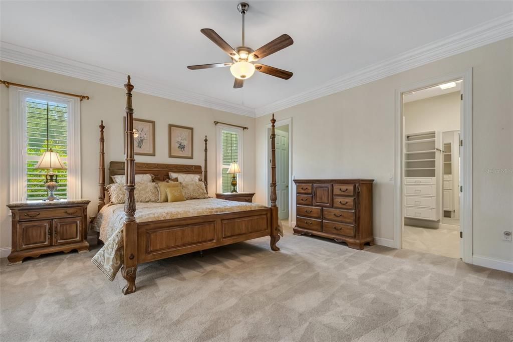 The owners suite has an exit onto the pool deck/lanai, features his and her separate walk in closets with built-ins, plantation shutters , high ceilings and an en-suite primary bathroom.