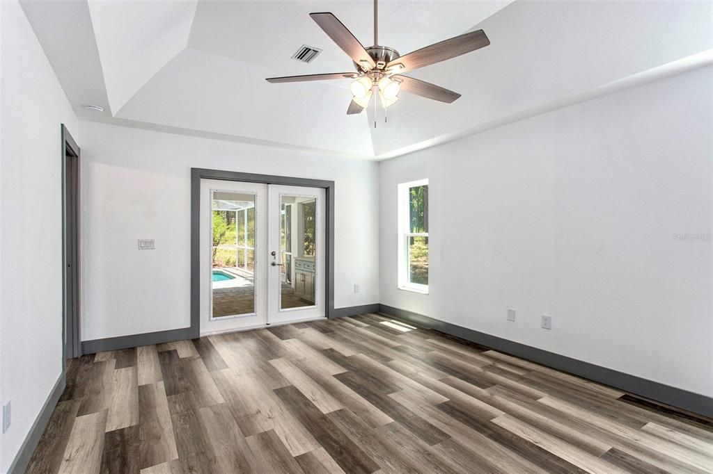 Separate master with tray ceiling & french doors to pool. This is a perfectly light-filled room!