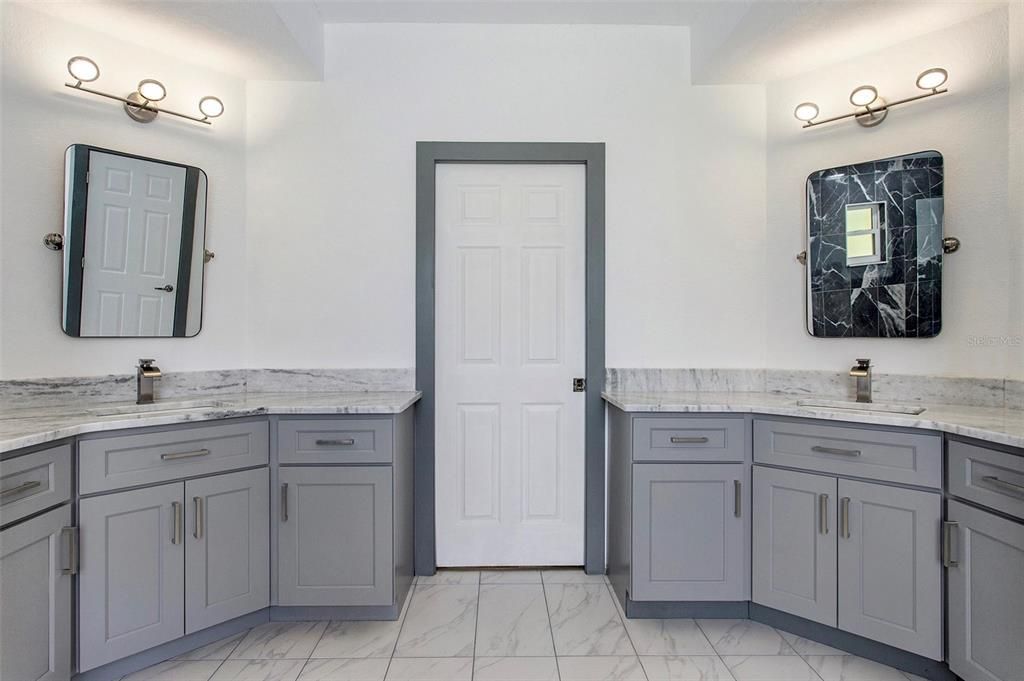 This renovated master bathroom boasts separate vanities with ample cabinet space, creating a perfect space to unwind, get ready for the day, and store your essentials.