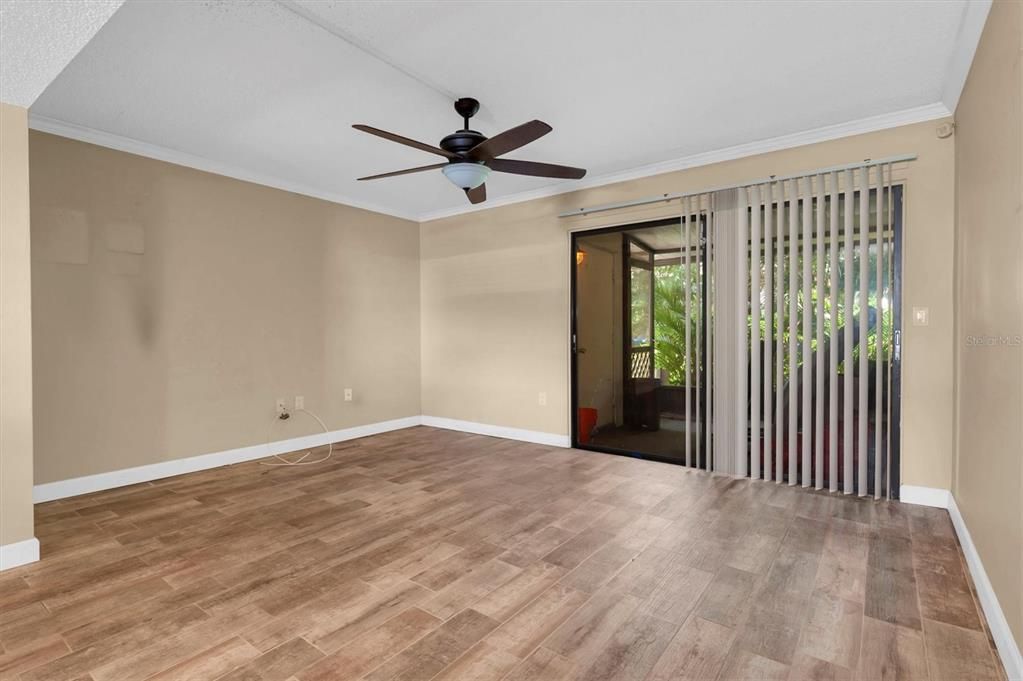 the downstairs living room, with screened porch beyond the sliders; there's also a laundry and utility closet on the back porch; go out through the screened door onto a lovely, shady green space out back surrounded by some other buildings