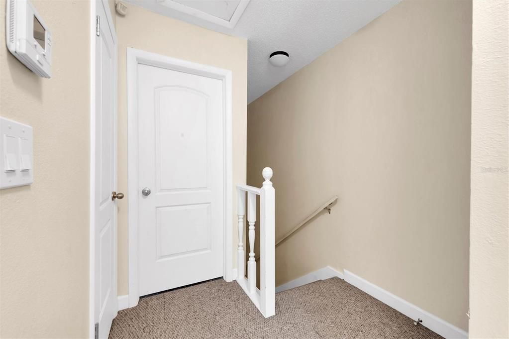 upstairs landing; door to all the way to the left goes to the upstairs bathroom (full bathroom), and the door directly ahead houses the central AC and electric hot water heater