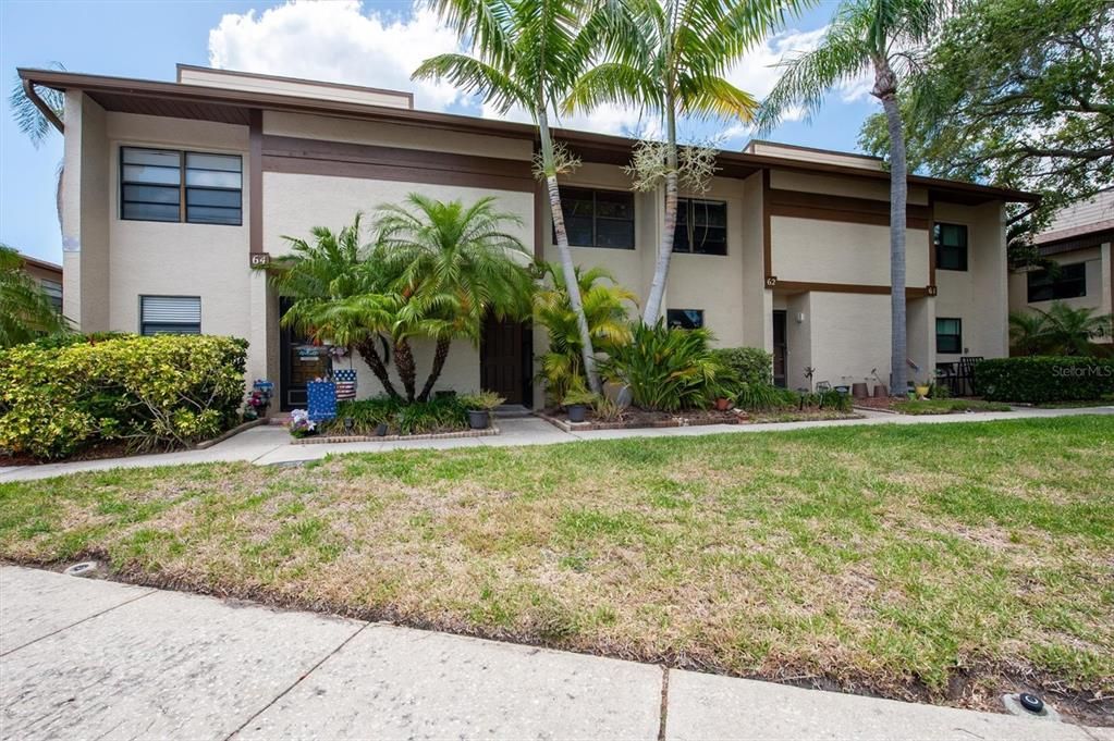 #63 is the second door from the left; there's a little patio behind the two giant palm trees, to the right of the front door; there's also a back patio that goes out onto the grassy area out back (laundry/utility room is also on the back porch, washer/dryer included)