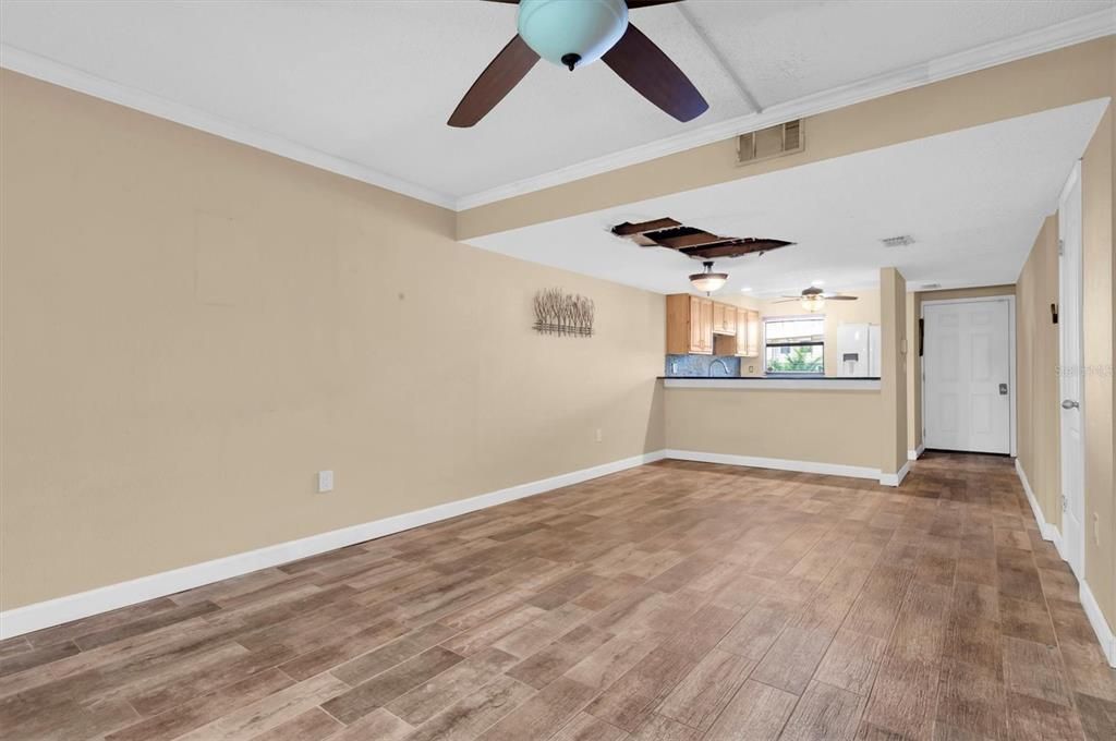 ceramic plank tile downstairs; the opening in the ceiling is from a plumbing line leak that has been repaired