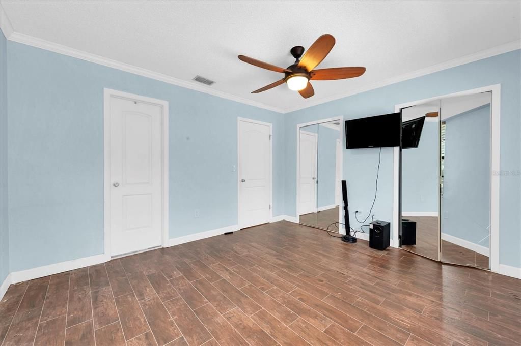 this is the back bedroom on the second floor, overlooks the green space; plank tile floors, huge closet behind mirrored doors; the door on the far left goes into the upstairs bathroom, shared by both bedrooms up here