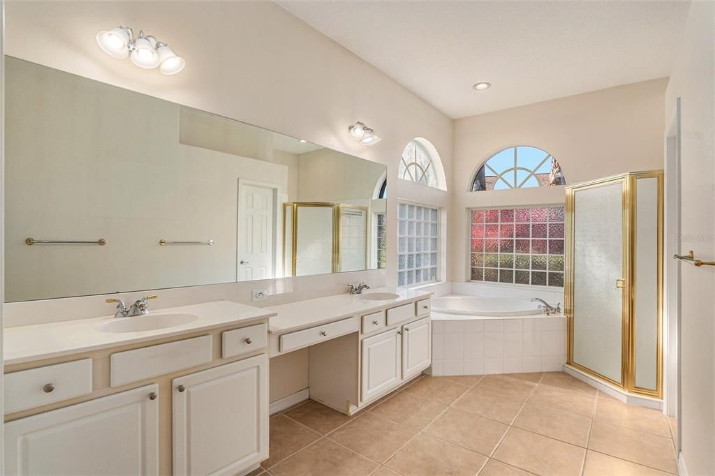 The master bathroom includes dual sinks, vanity space, a walk-in shower, and spa tub, creating a spa-like atmosphere.