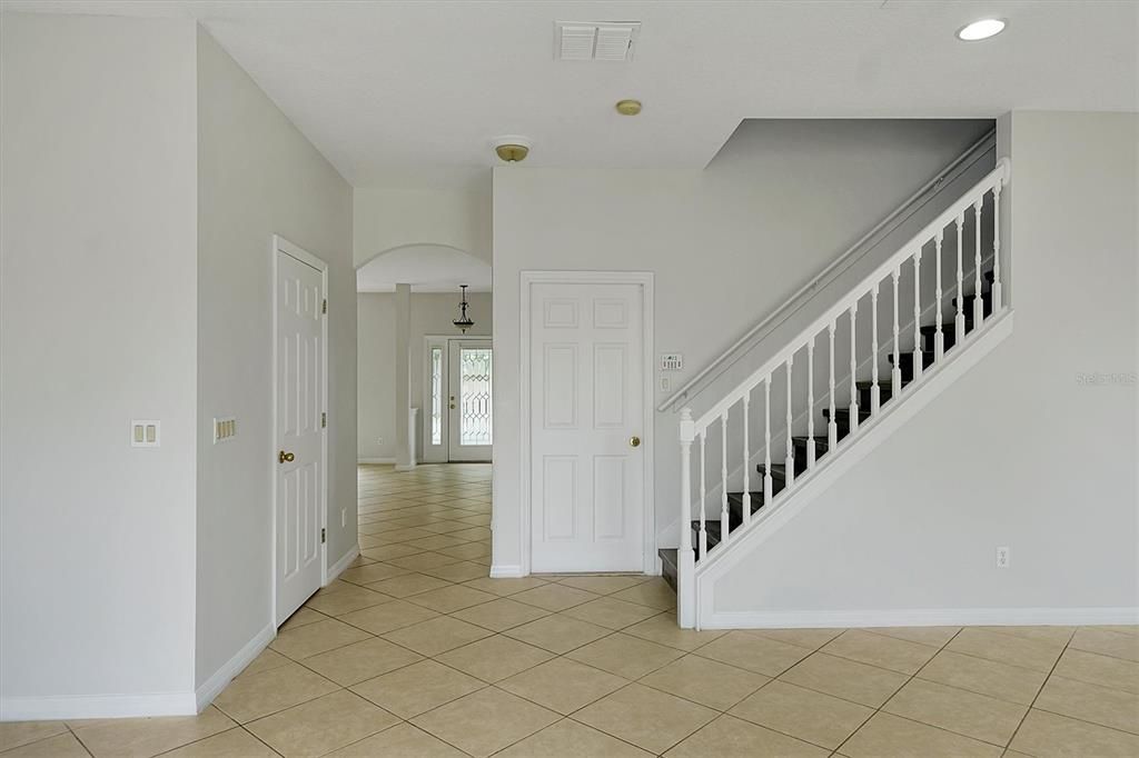 Door by stairs leads to 2 car garage with separate large storage area.  Door to left is the half bath.  Formal living room/dining room is in the front
