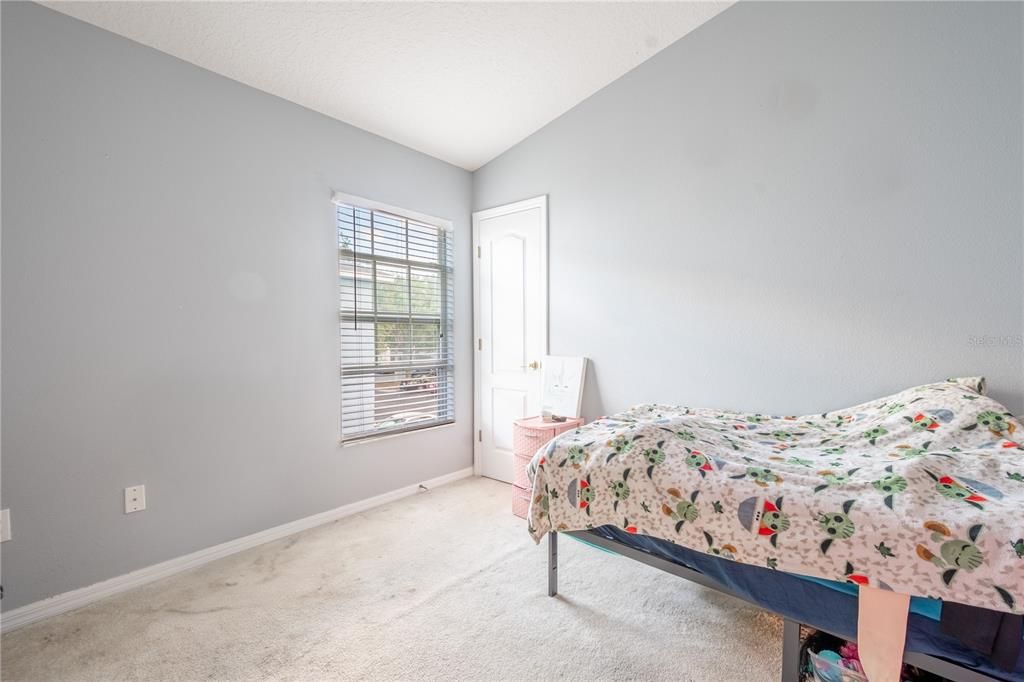 Bedroom 3 features a vaulted ceiling, carpet, neutral color palette and a built in closet.