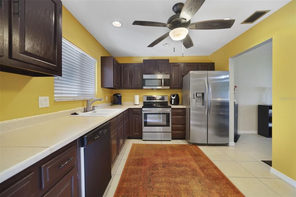 The cheerful kitchen has space to eat in, plenty of cabinet/counter space and quality appliances.
