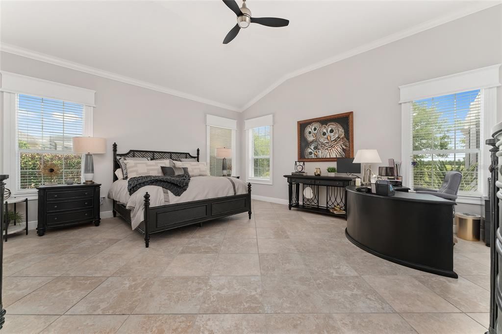 The elegant PRIMARY BEDROOM is super spacious w/ VAULTED CEILING.  Due to SOUTHERN REAR EXPOSURE, NATURAL LIGHT abounds & produces beautiful sunrise views of the Prairie! Note CROWN MOLDING & extensive custom woodworking around windows.