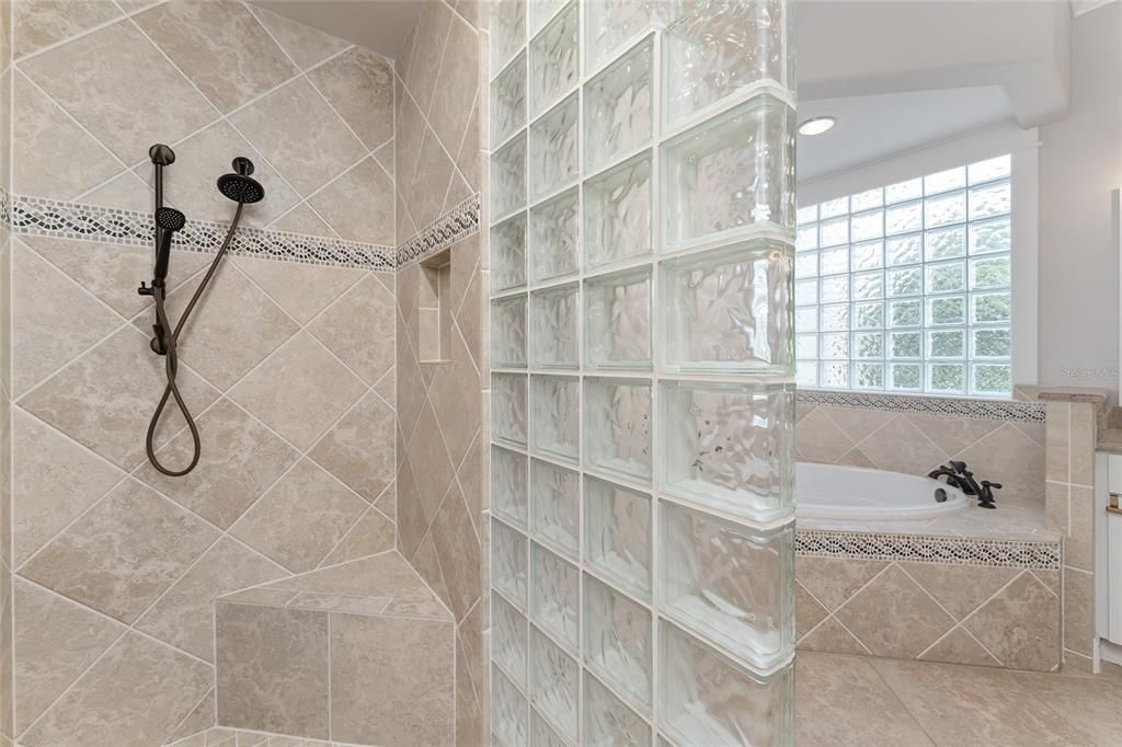 ENSUITE BATHROOM features GLASS BLOCK WINDOW & GLASS BLOCK WALL in ROMAN SHOWER that invites NATURAL LIGHT.