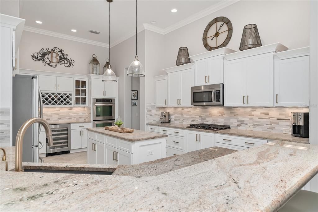 KITCHEN - Note how GRANITE COUNTERTOPS blend beautifully with chic TILE BACKSPLASH.