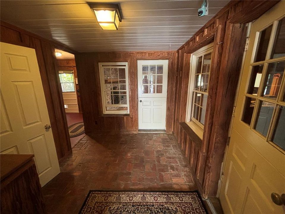 Main entry to home from carport. First door on left leads to MIL suite. Second on left leads to back patio. First door on right leads to kitchen. Door directly ahead leads to dining room.